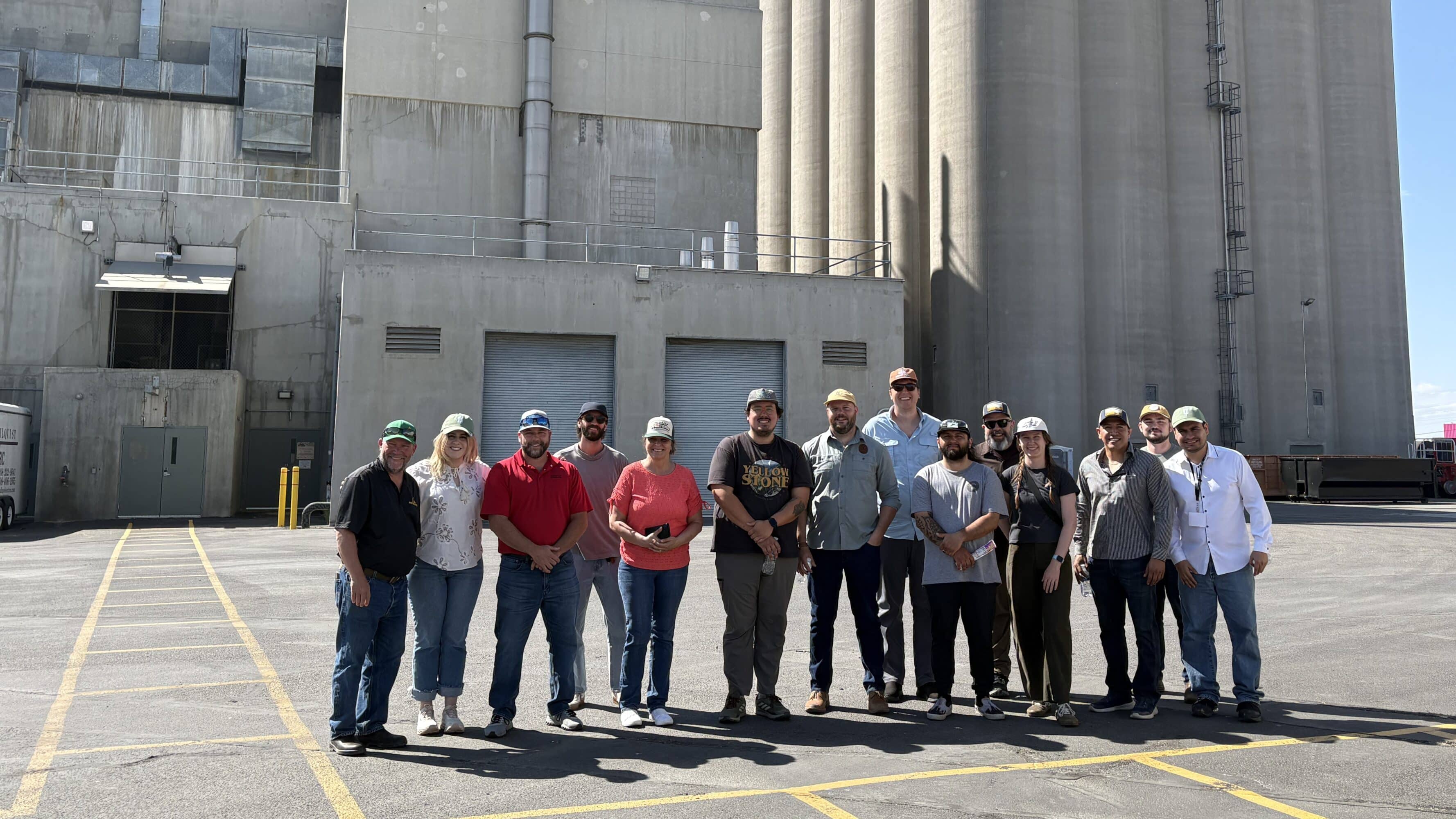 Brewing and distilling customers visiting Great Western Malting plant in Pocatello standing in front of malthouse